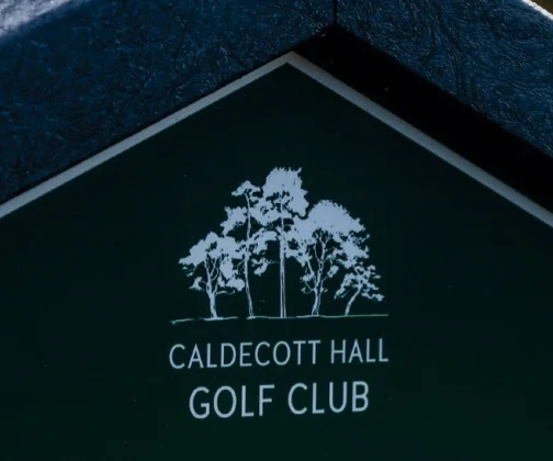 The crest of Caldecott Hall Golf Club on its JB Golf tee sign