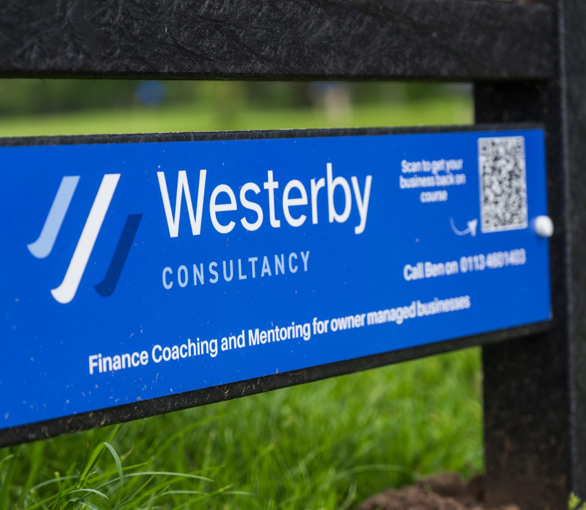 A sponsor’s panel fixed to the tee sign of a golf hole.