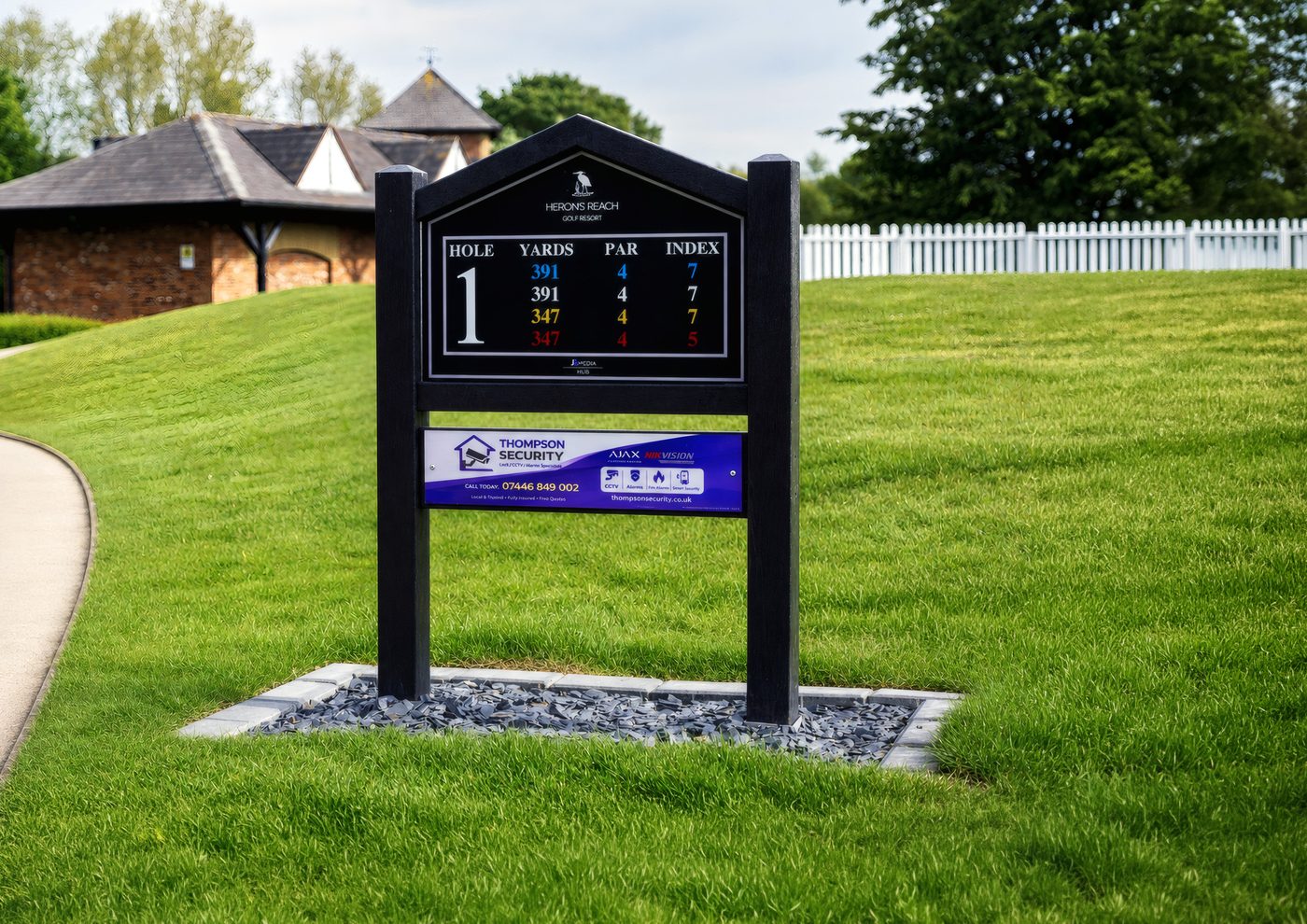 A newly installed tee sign standing on its base at the edge of a fairway.